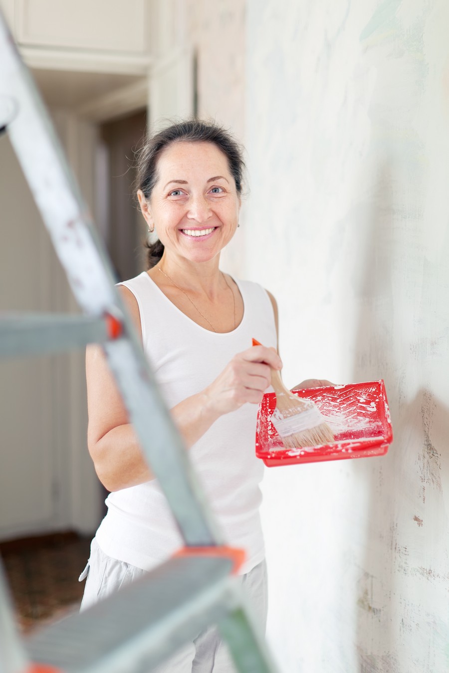 Happy mature woman makes repairs at home